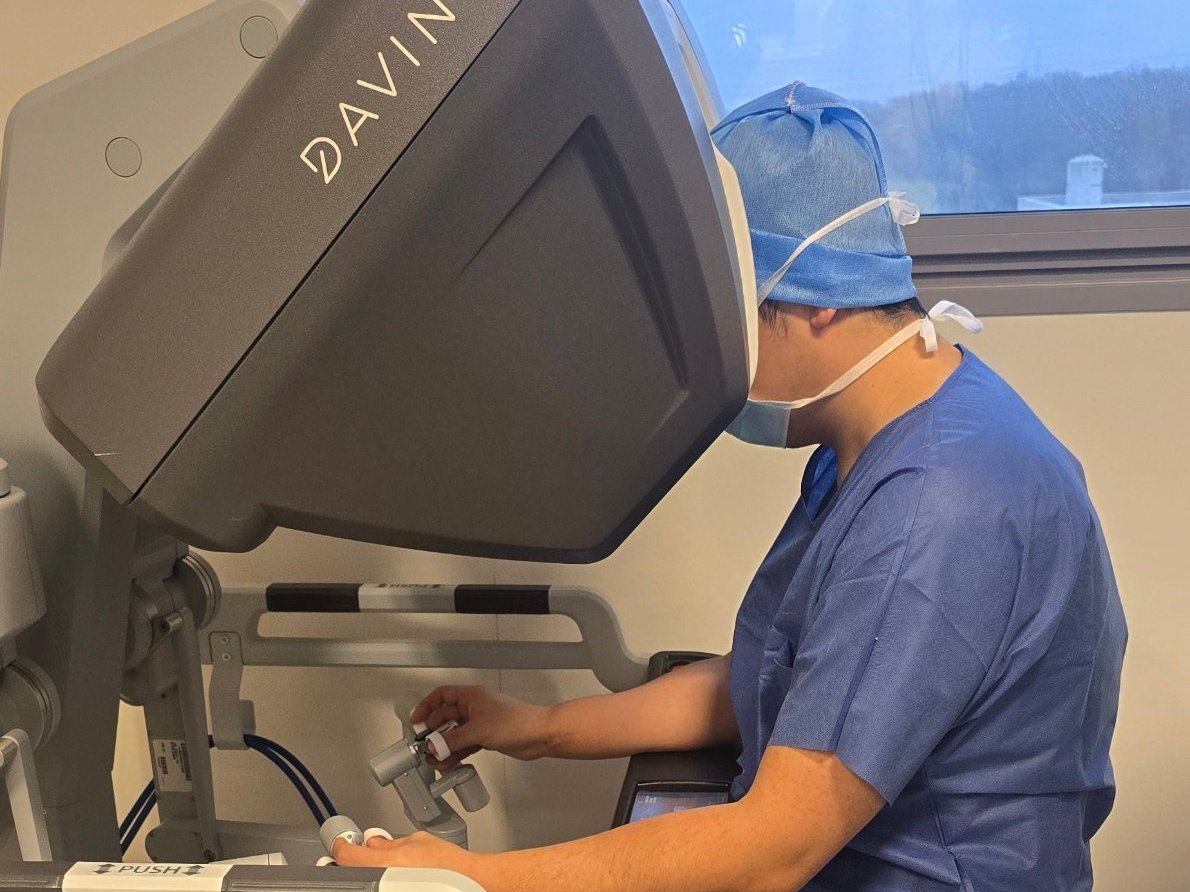 Le Dr Haixia Ye opère assis à la console du robot Da Vinci X
